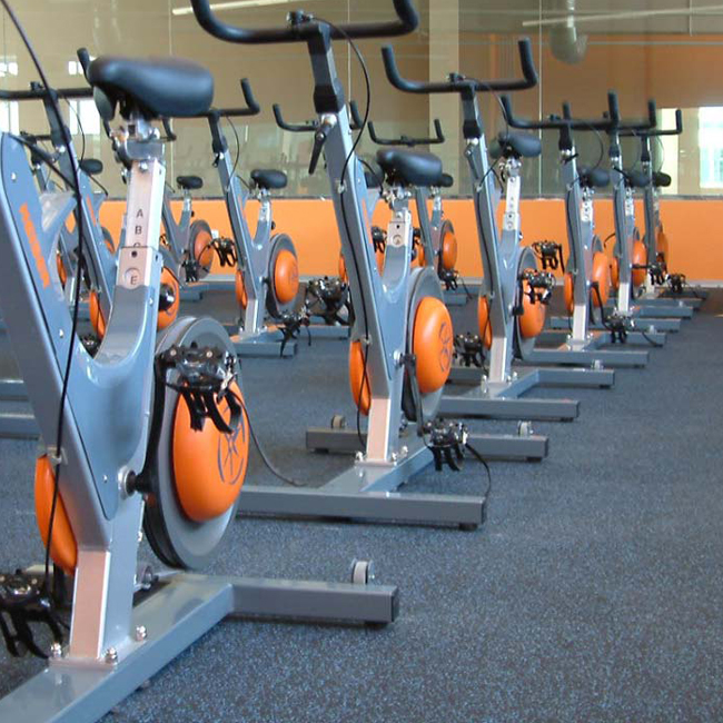 Rubber gym flooring installed under strength training equipment in a commercial gym