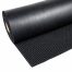 Black rubber fingertip mat on roll with raised rubber studs on the surface, suitable for entrances and industrial applications.