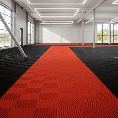 Red and black interlocking floor tiles installed in a modern automotive showroom